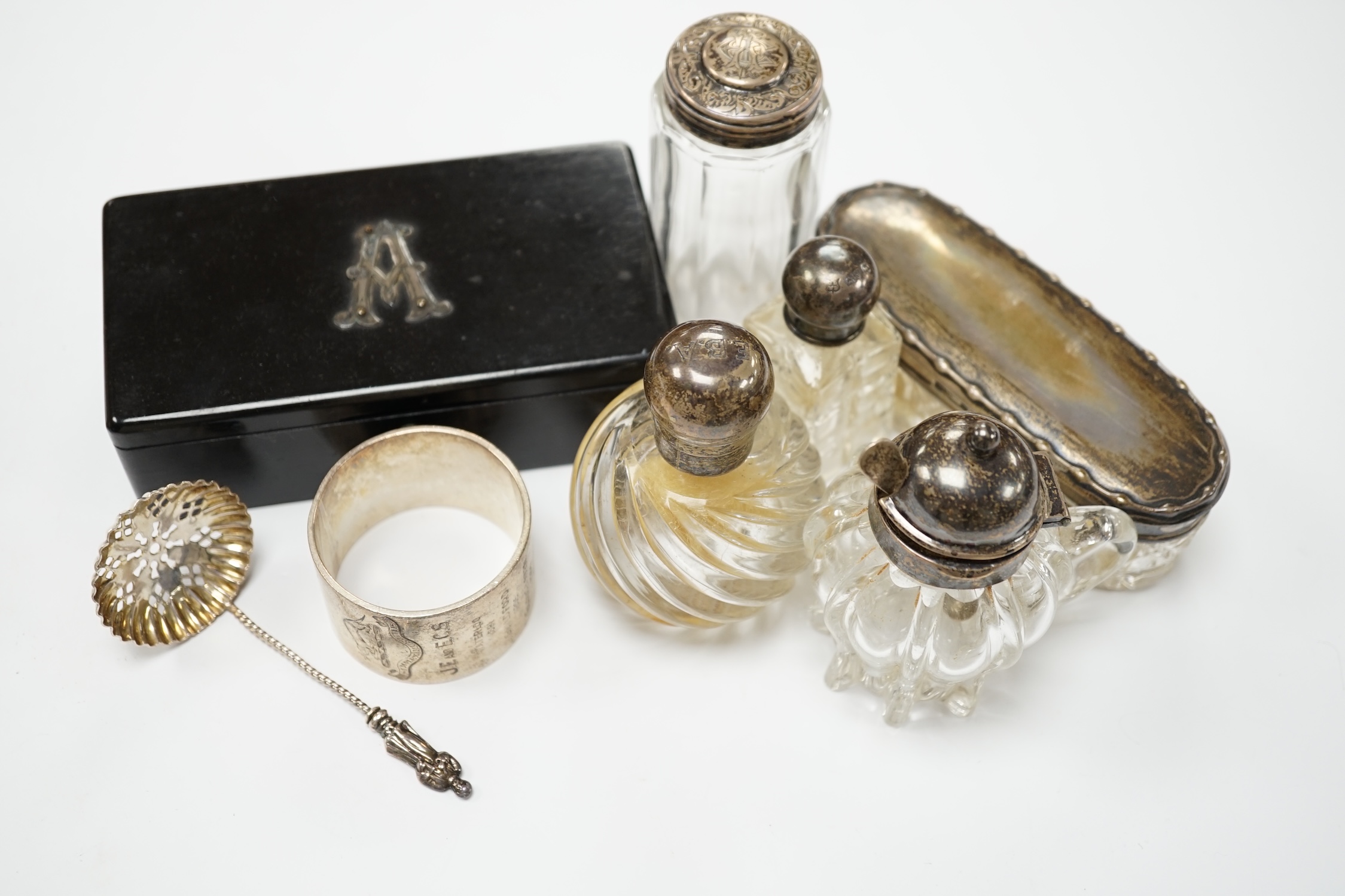 Four assorted silver mounted glass toilet jars, an Edwardian silver mounted glass mustard jar with spoon, a silver napkin ring, sifter spoon and ebony box. Condition - poor to fair